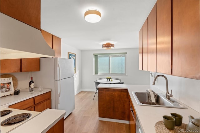 kitchen with sink, light wood-type flooring, white refrigerator, and exhaust hood