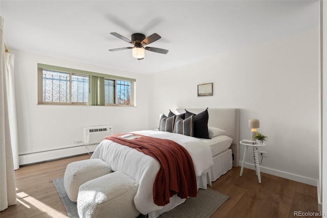 bedroom with ceiling fan, baseboard heating, wood-type flooring, and a wall unit AC