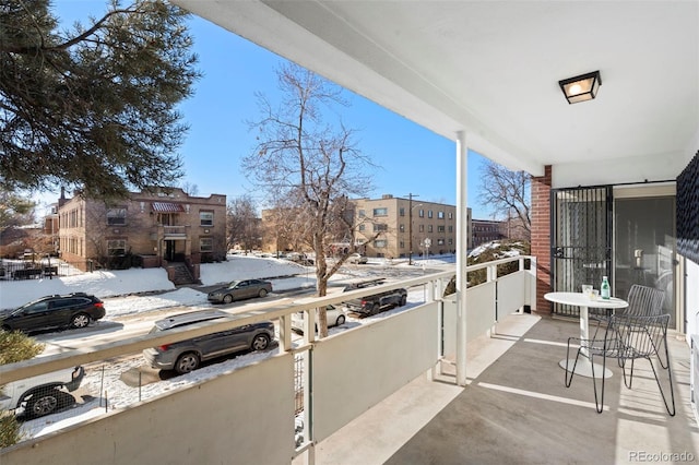 snow covered patio with a balcony