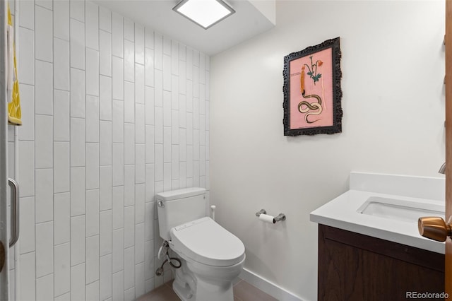 bathroom with tile walls, toilet, and vanity