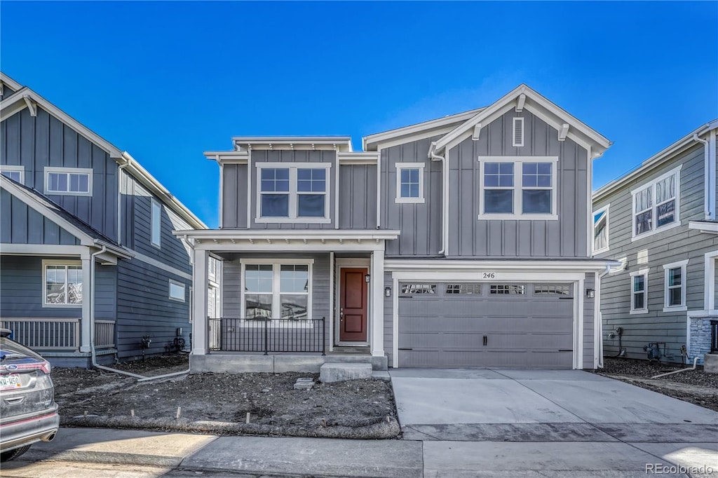 view of front of house with board and batten siding, a porch, driveway, and a garage