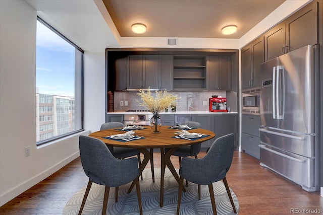 dining space with dark hardwood / wood-style floors and sink