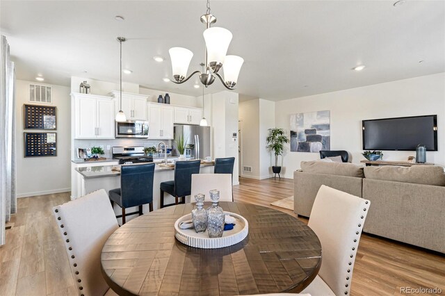 dining area featuring a notable chandelier and light hardwood / wood-style flooring