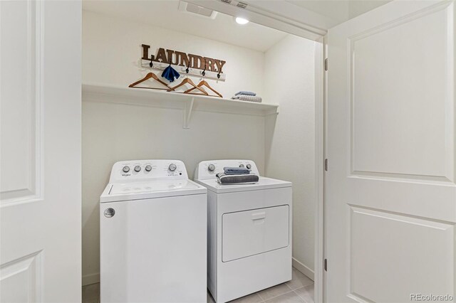 washroom with light tile patterned flooring and washer and dryer