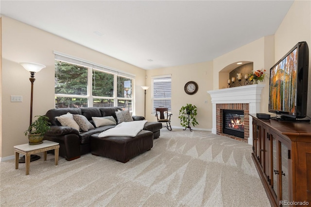 living room with light colored carpet, a brick fireplace, and baseboards