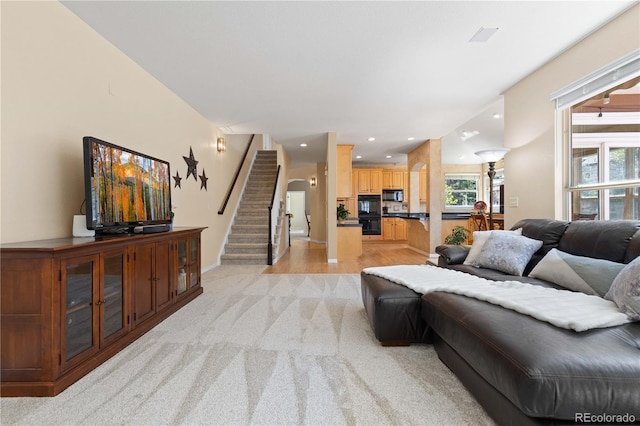 living room with light colored carpet, stairs, baseboards, and recessed lighting