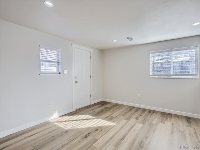 spare room with light wood-style floors, baseboards, recessed lighting, and visible vents