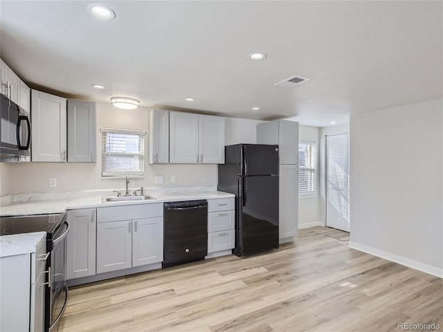 kitchen with a sink, baseboards, black appliances, and recessed lighting