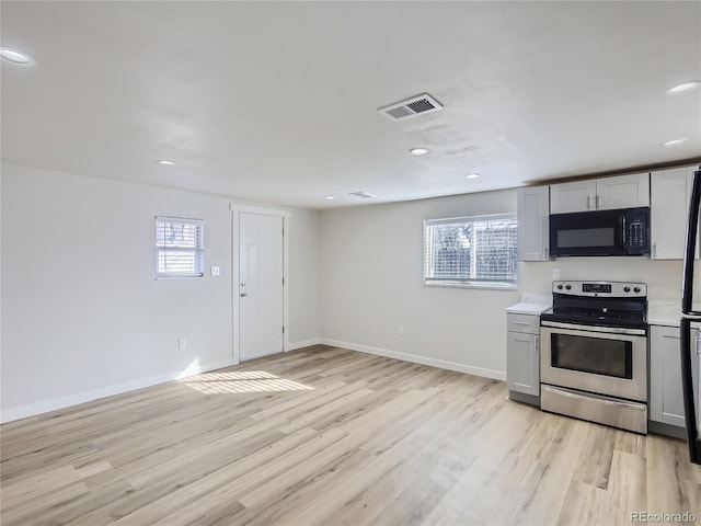kitchen with visible vents, black microwave, recessed lighting, light wood-style flooring, and stainless steel electric range oven