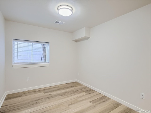 spare room with baseboards, visible vents, and light wood-type flooring