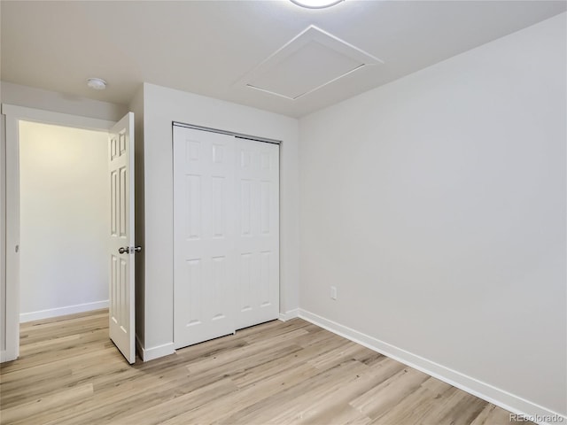unfurnished bedroom with baseboards, a closet, and light wood finished floors