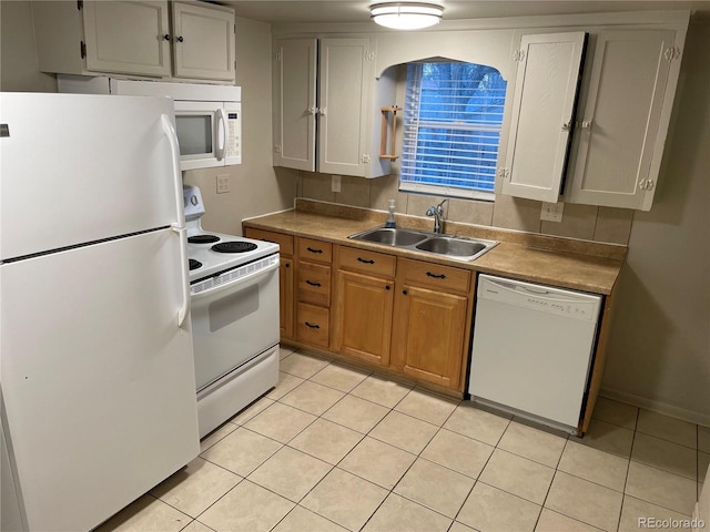kitchen featuring white appliances, light tile patterned flooring, a sink, and light countertops