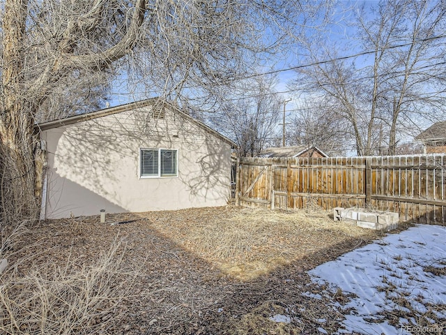 snowy yard featuring fence