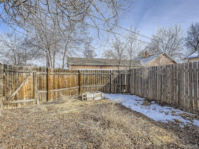 yard covered in snow with fence and a gate