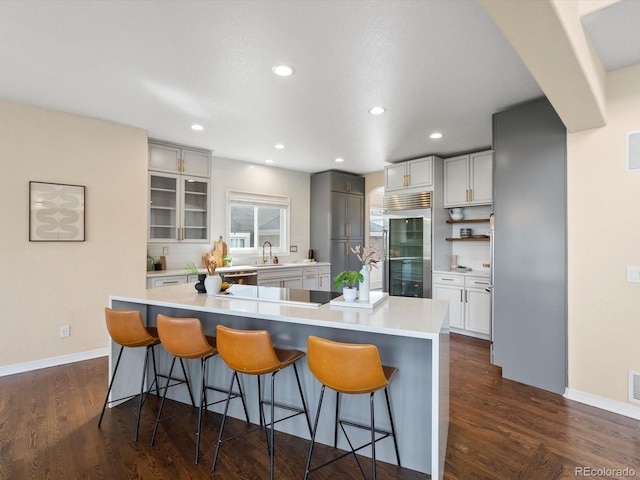 8425 Green Island Cir, Lone Tree, CO 80124 - kitchen featuring black electric cooktop, high quality fridge, a kitchen bar, recessed lighting, and light countertops