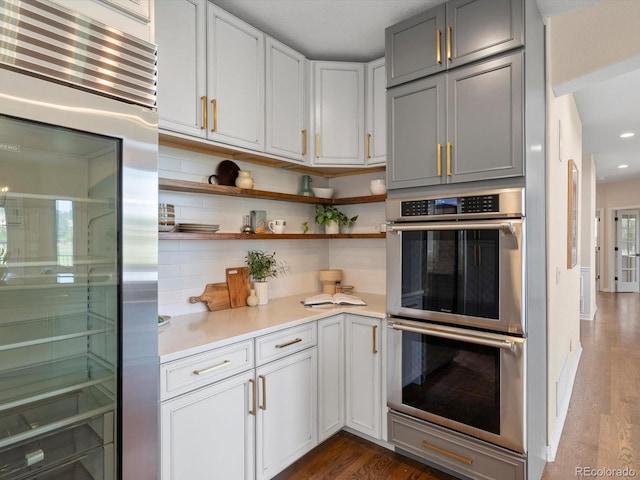8425 Green Island Cir, Lone Tree, CO 80124 - kitchen with appliances with stainless steel finishes, backsplash, dark wood-type flooring, light countertops, and gray cabinetry