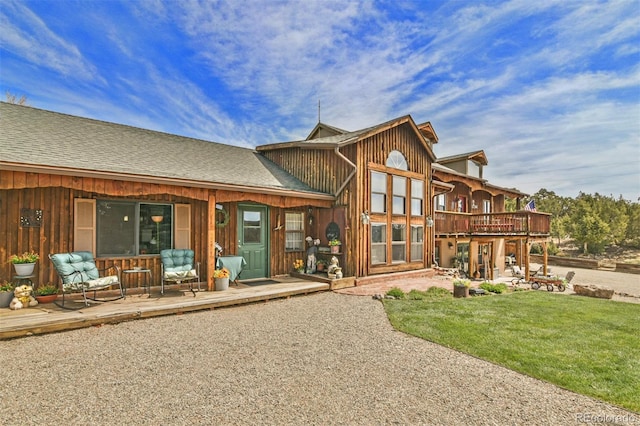 24857 US Highway 160, Walsenburg, CO 81089 - back of property with a patio, a wooden deck, a lawn, and board and batten siding