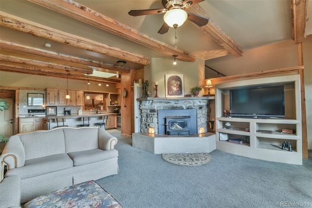 24857 US Highway 160, Walsenburg, CO 81089 - living area featuring beam ceiling, carpet flooring, a ceiling fan, and a wood stove