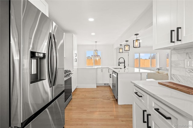 kitchen featuring white cabinetry, appliances with stainless steel finishes, sink, and light stone counters