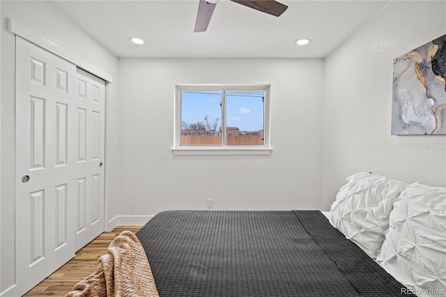 bedroom with hardwood / wood-style flooring, a closet, and ceiling fan