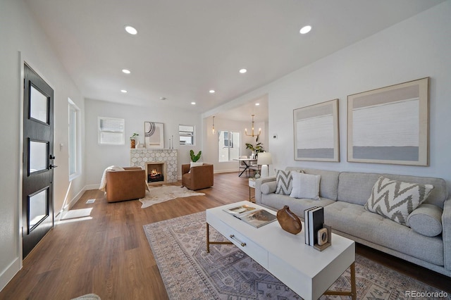 living room featuring a chandelier, hardwood / wood-style floors, and a fireplace