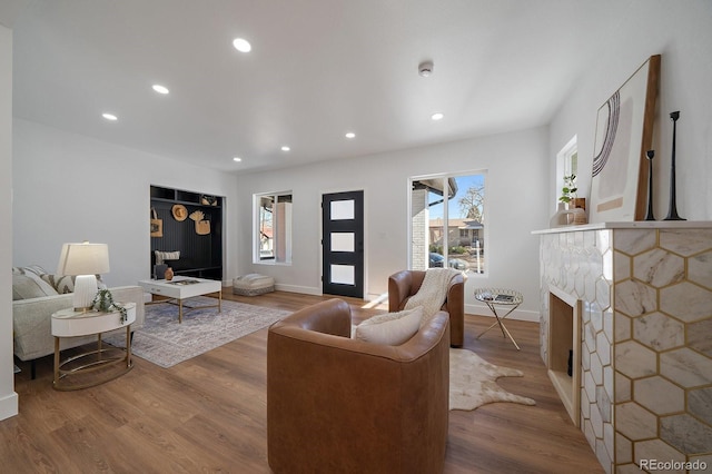 living room featuring a stone fireplace and hardwood / wood-style floors