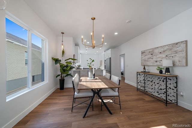 dining area featuring dark wood-type flooring and a chandelier