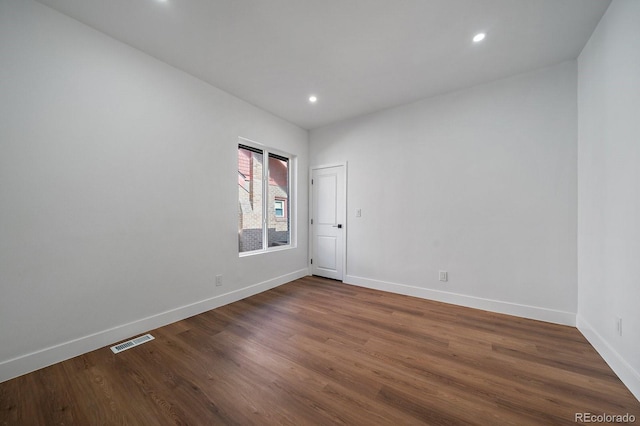 empty room with dark hardwood / wood-style flooring