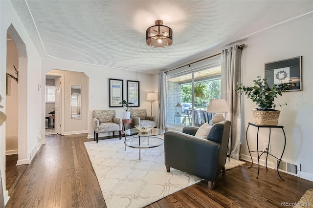 living room with a textured ceiling and dark hardwood / wood-style floors