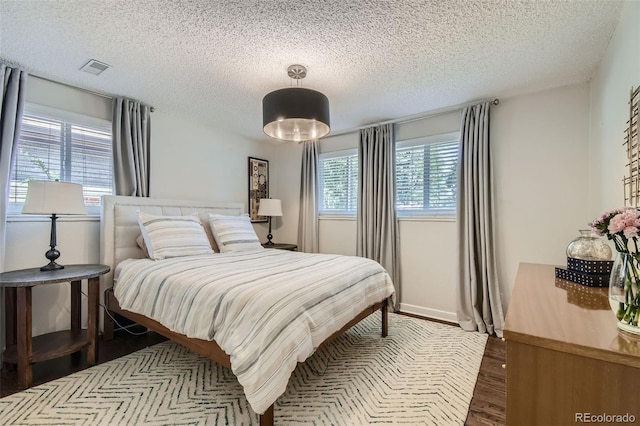 bedroom featuring dark hardwood / wood-style floors and a textured ceiling