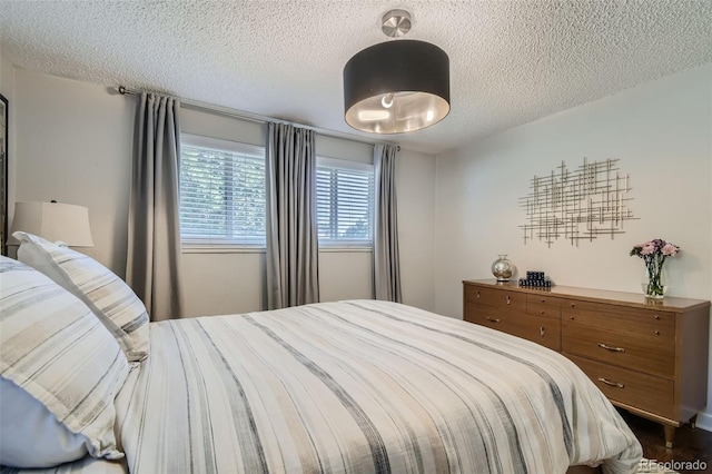 bedroom featuring a textured ceiling and dark hardwood / wood-style floors