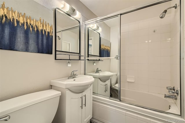 full bathroom featuring bath / shower combo with glass door, vanity, and toilet