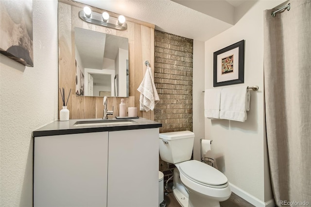 bathroom featuring toilet, vanity, and a textured ceiling