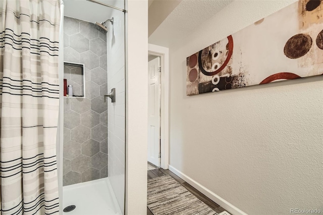 bathroom with a shower with curtain, wood-type flooring, and a textured ceiling