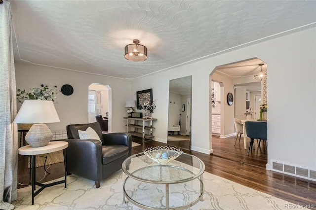 living room with wood-type flooring and crown molding