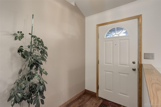 entryway featuring baseboards, dark wood-type flooring, and vaulted ceiling