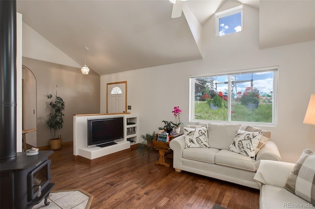 living room featuring high vaulted ceiling, a wood stove, ceiling fan, and dark wood-style flooring