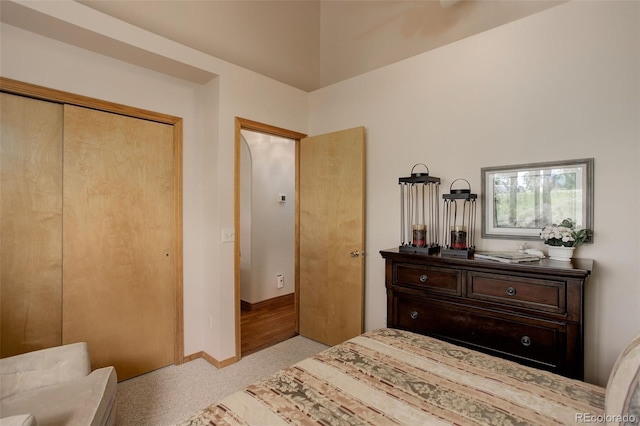 carpeted bedroom with baseboards and a closet