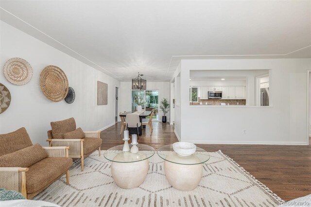 2644 S Krameria St, Denver, CO 80222 - living room with wood finished floors, a chandelier, and baseboards