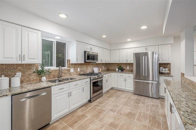 2644 S Krameria St, Denver, CO 80222 - kitchen with stainless steel appliances, a sink, tasteful backsplash, white cabinets, and light stone counters