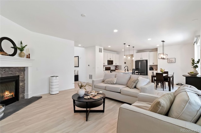 1369 E Witherspoon Dr, Elizabeth, CO 80107 - living area with light wood-style flooring, a stone fireplace, and recessed lighting