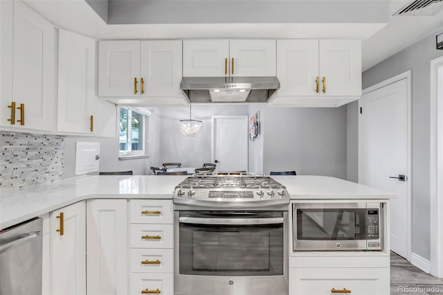 kitchen with wood-type flooring, white cabinets, stainless steel appliances, and backsplash