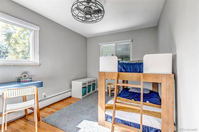 bedroom featuring wood-type flooring and a baseboard radiator