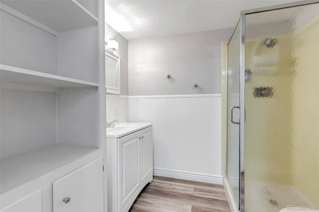 bathroom with a shower with door, vanity, and wood-type flooring