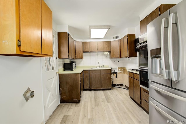 7291 Bryant St, Westminster, CO 80030 - kitchen featuring stainless steel fridge, light wood-style flooring, a sink, light countertops, and oven