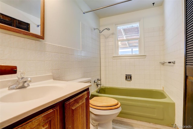 7291 Bryant St, Westminster, CO 80030 - bathroom featuring tile walls, toilet, vanity, bathtub / shower combination, and wood finished floors