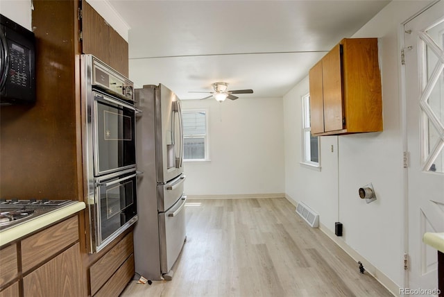 7291 Bryant St, Westminster, CO 80030 - kitchen with stainless steel refrigerator with ice dispenser, black microwave, a ceiling fan, light wood-style floors, and brown cabinets