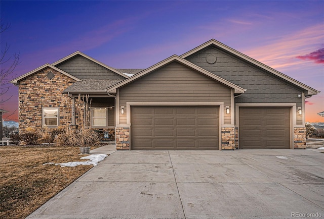 view of front of property with a garage, stone siding, and concrete driveway