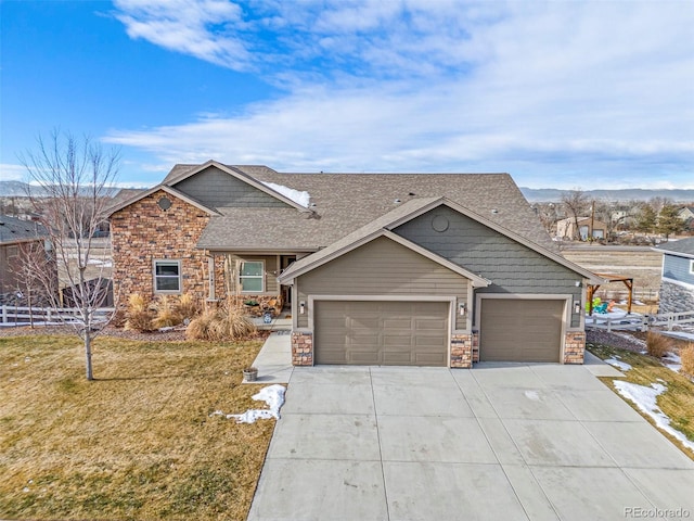 view of front of property featuring a garage, stone siding, driveway, and a front lawn