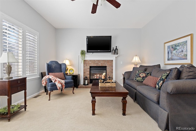 carpeted living room with visible vents, a fireplace, baseboards, and ceiling fan